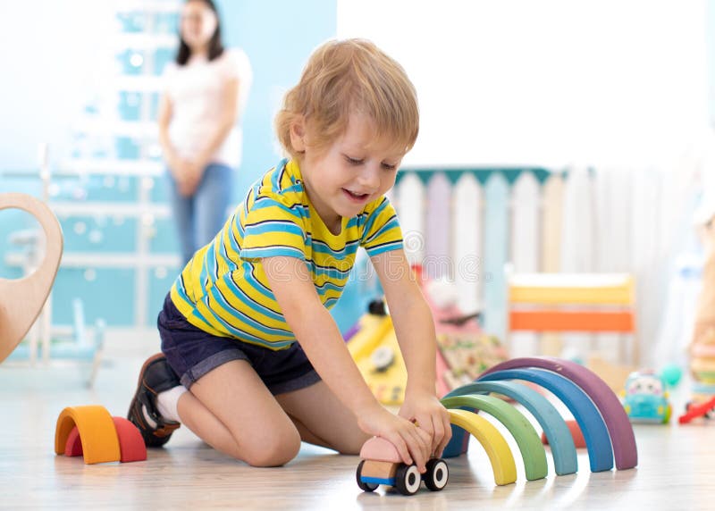 Kid toddler playing wooden toys in kindergarten or nursery stock photos Kid toddler playing wooden toys in kindergarten or nursery stock photos