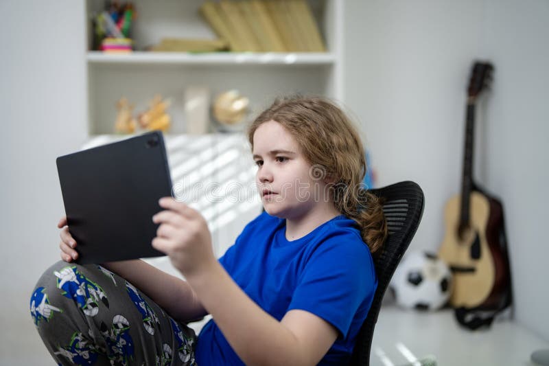 Kid using laptop for school study. Teen kid studying online school class. Kid during school lesson. Kid watching school lesson stock photo