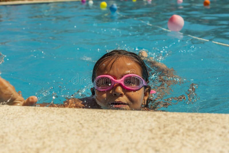 Child Wearing Goggles, Breathing while Swimming in the Pool. Stock