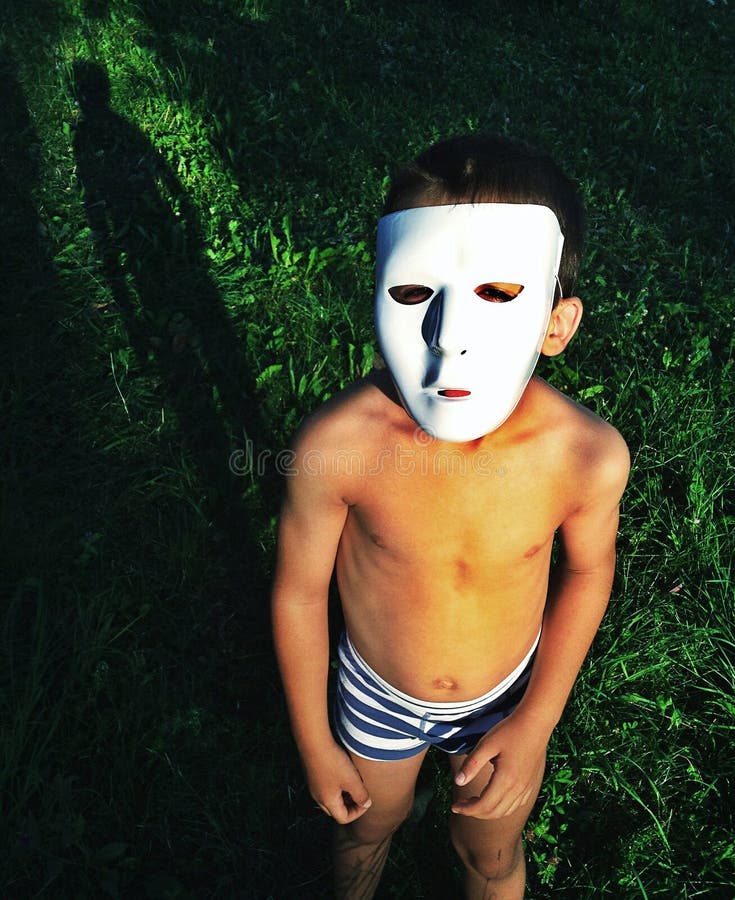 Bambino che indossa la maschera in un giardino, alla ricerca di strano.