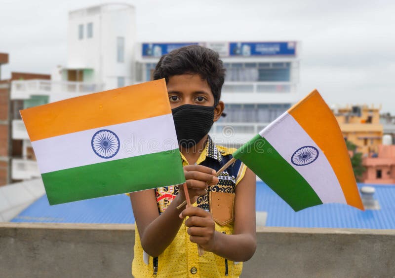 KID WEARING MASK and HOLDING INDIAN FLAG in India Stock Photo Image
