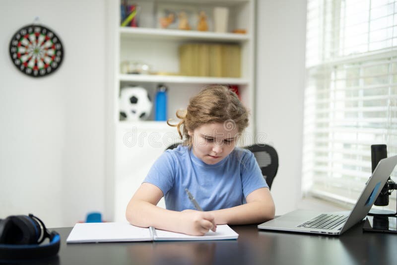 Kid writing lesson during online learning. Remote school lesson. Serious focused student writing. Homeschooling with child writing royalty free stock images