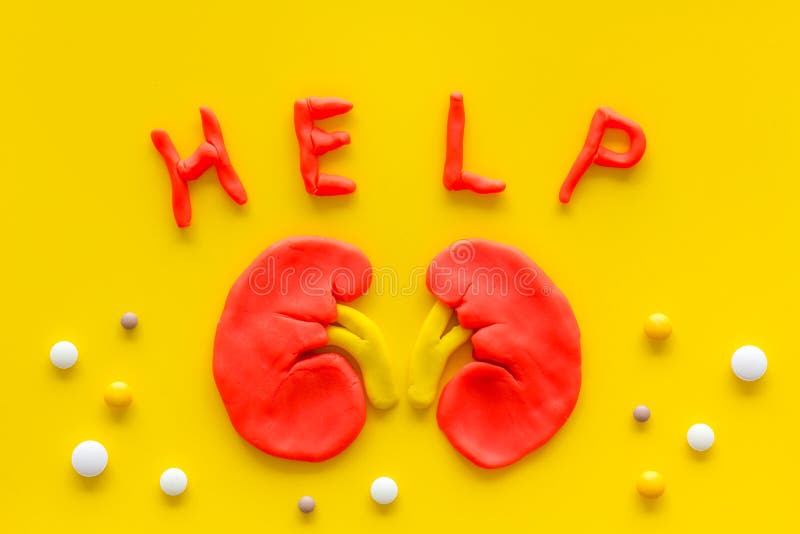 Kidney illness and treatment. Word help, organ, pills on yellow background top view.