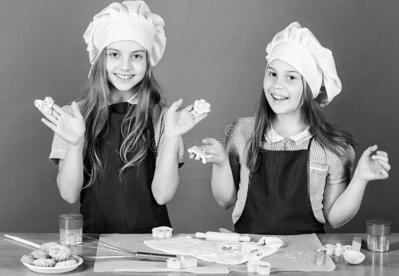 Kids baking cookies together. Kids aprons and chef hats cooking. Family recipe. Culinary education. Mothers day. Baking royalty free stock photo Kids baking cookies together. Kids aprons and chef hats cooking. Family recipe. Culinary education. Mothers day. Baking royalty free stock photo
