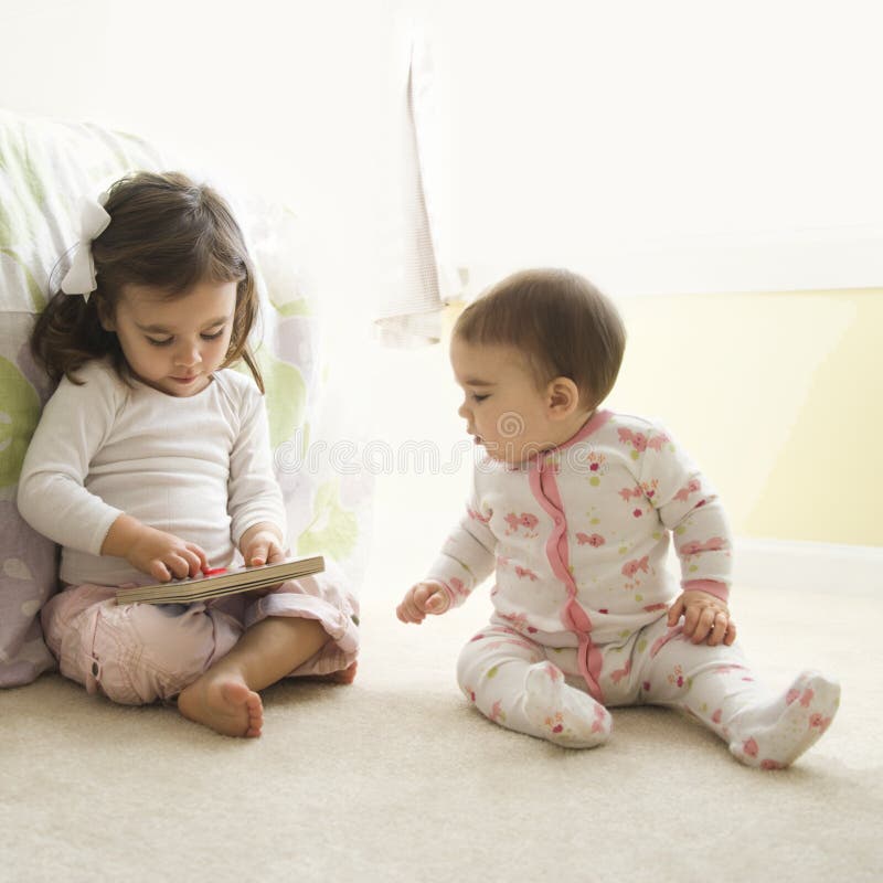 Caucasian girl children sitting on bedroom floor looking at book. Caucasian girl children sitting on bedroom floor looking at book.