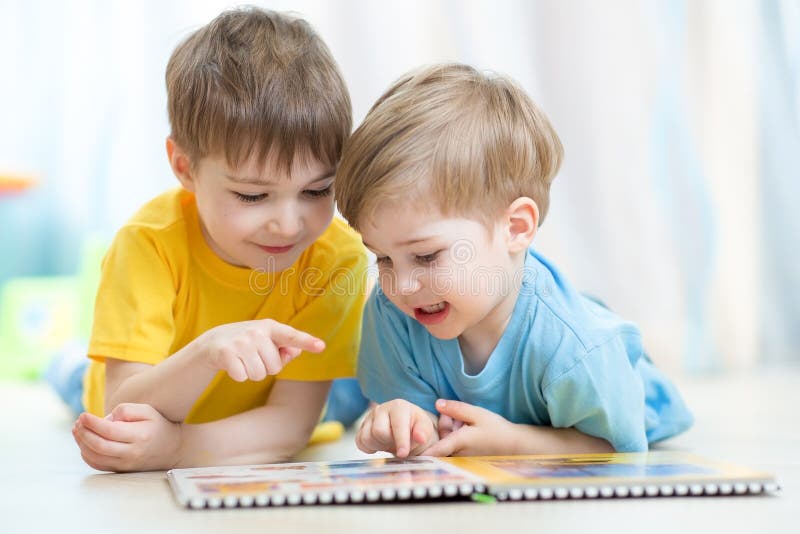 Fratelli pratica lettura comune guarda un libro dire bugie sul pavimento.