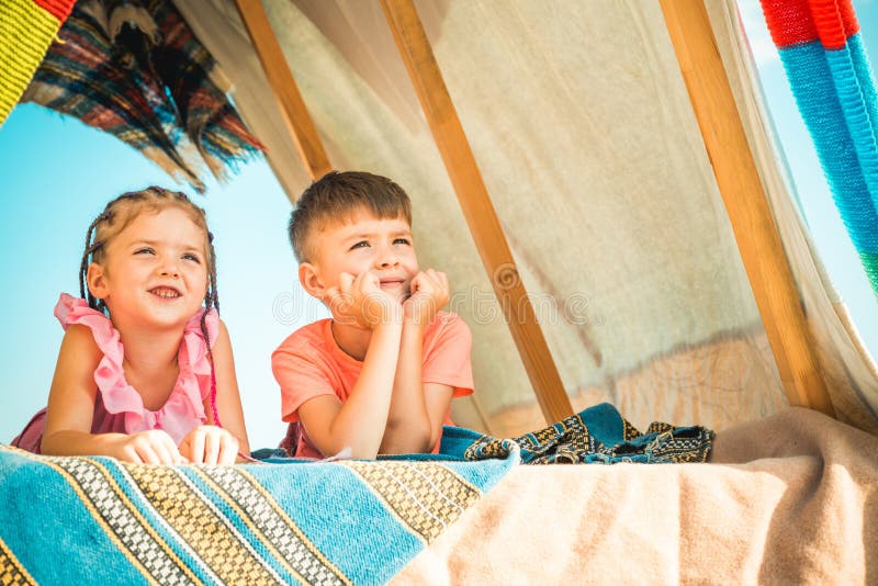 Sisters spending time in a tent on camping. Children using tablet playing games  online during summer vacation - a Royalty Free Stock Photo from Photocase