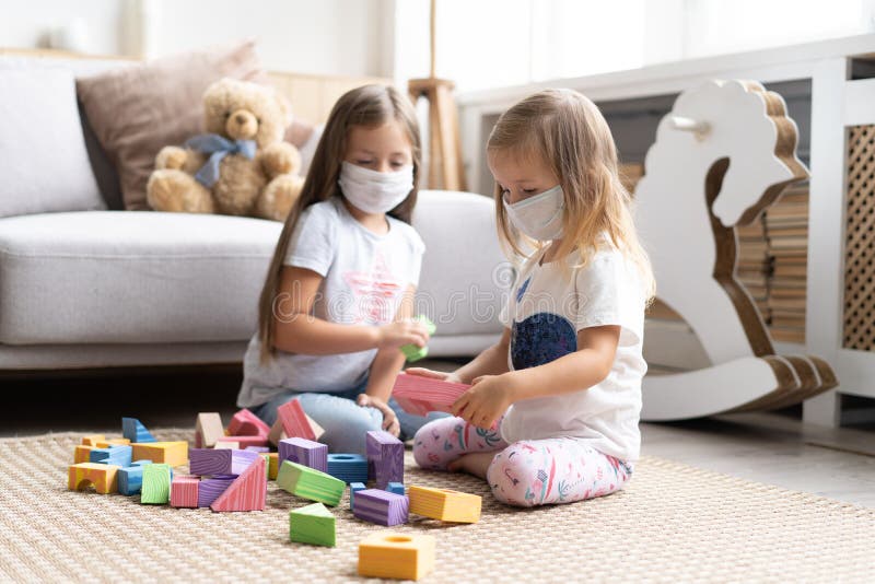 Kids children wearing mask for protect Covid-19, playing block toys in playroom.