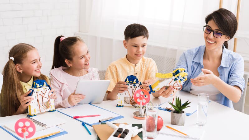 Kids creating robots with teacher in classroom royalty free stock image