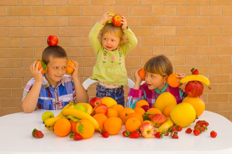 Kids playing and eating various lovely fruits. Bananas, oranges, apples, grapefruit, strawberries, pomelo,. Kids playing and eating various lovely fruits. Bananas, oranges, apples, grapefruit, strawberries, pomelo,