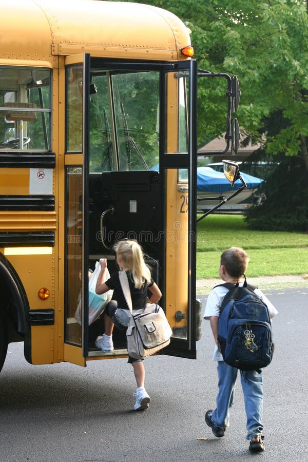 Ragazzo e ragazza di salire sul bus della scuola.