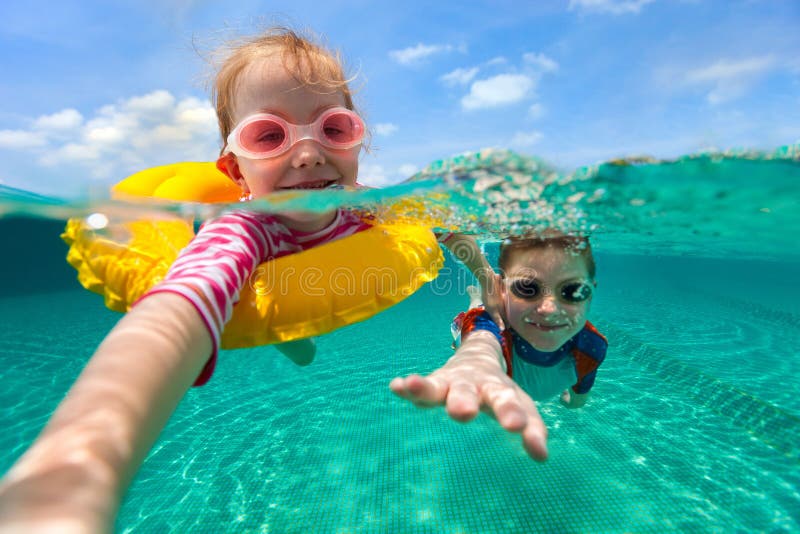 Split vyššie a podvodná fotografiu rozkošný deti baví plávanie na letnú dovolenku.