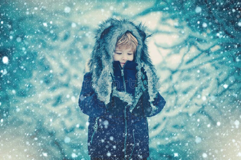 Kids having fun in white snow field against snowy trees. Kids winter portrait. Child playing in the snowy field in