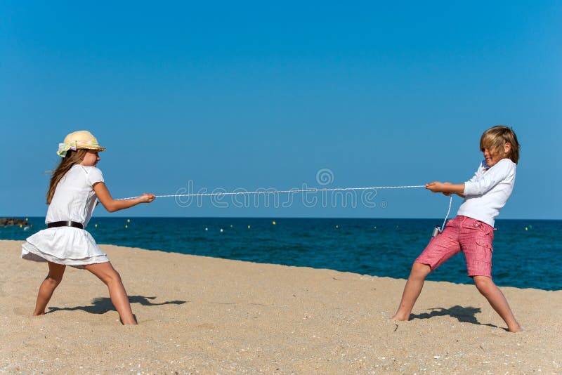 Boy and girl pulling the rope on the beach. Boy and girl pulling the rope on the beach.