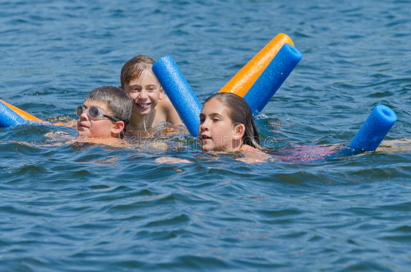 Kids having summer fun swimming in lake stock images Kids having summer fun swimming in lake stock images