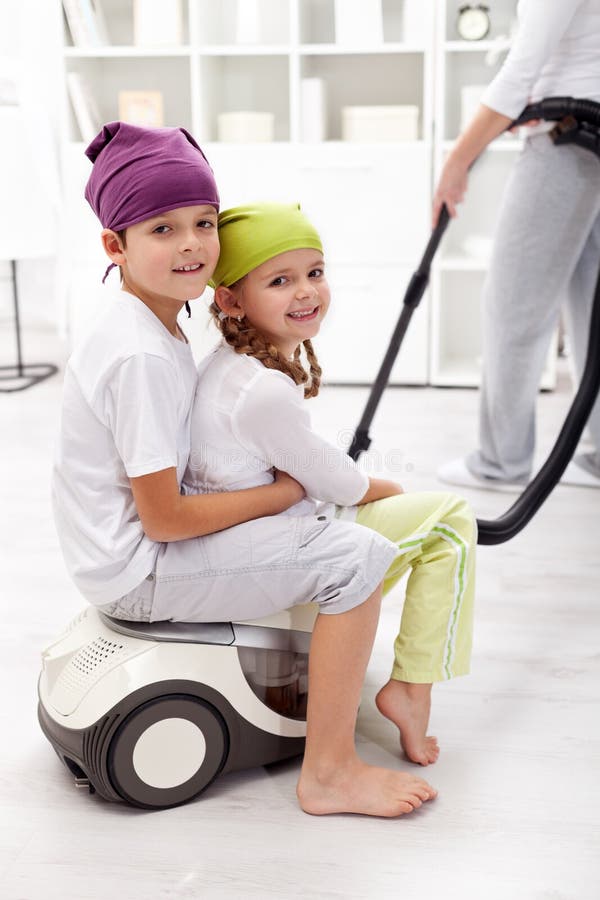 Kids having fun helping their mother cleaning the room. Kids having fun helping their mother cleaning the room