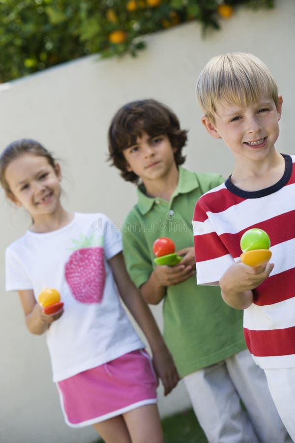 Kids Holding Eggs In Spoons For Egg Race stock photo
