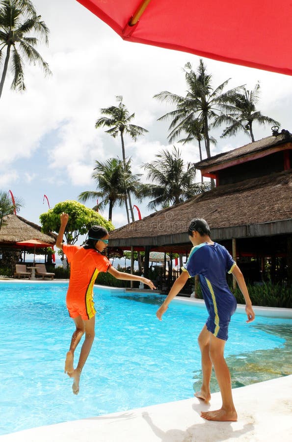 Kids jumping into resort pool