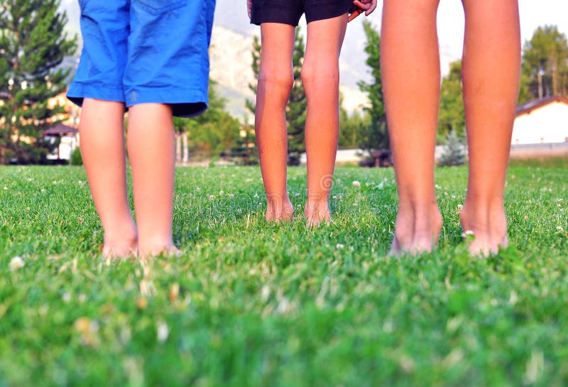 Kids Legs of a Small Child Standing on a Wooden Floor Near Pool during