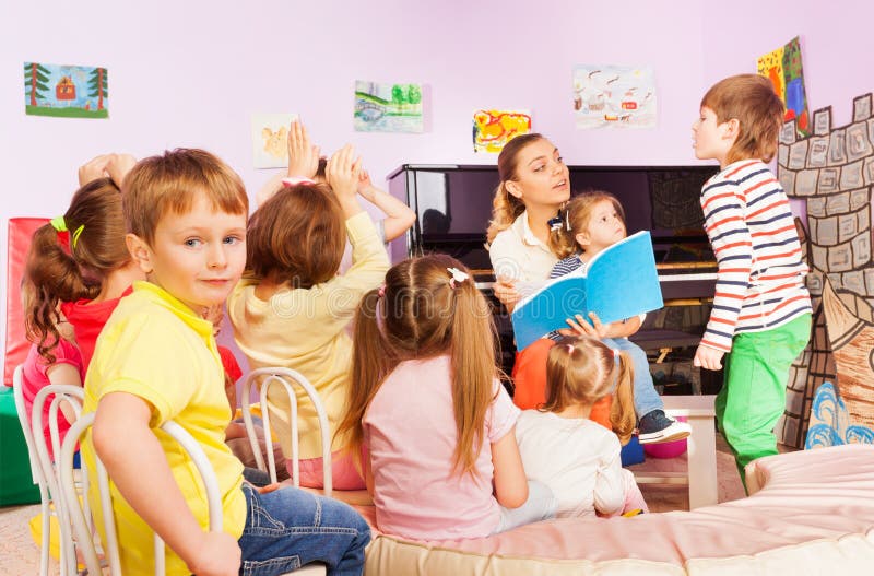 Kids Listen To Teacher Reading Book in Class Stock Image - Image of ...