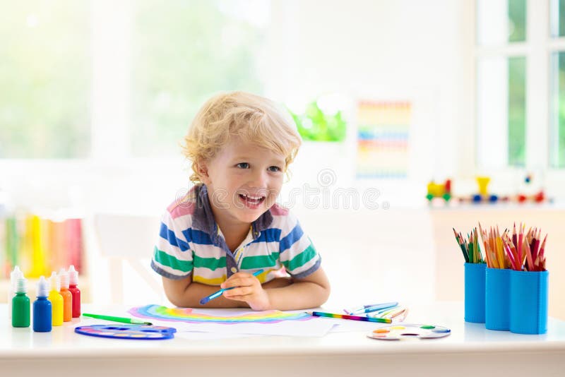 Kids paint. Child painting. Little boy drawing. Kids paint. Child painting in white sunny study room. Little boy drawing rainbow. School kid doing art homework stock photos Kids paint. Child painting. Little boy drawing. Kids paint. Child painting in white sunny study room. Little boy drawing rainbow. School kid doing art homework stock photos