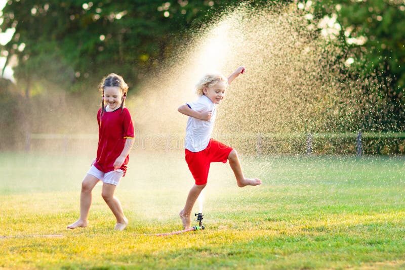 Kids play with water. Child with garden sprinkler