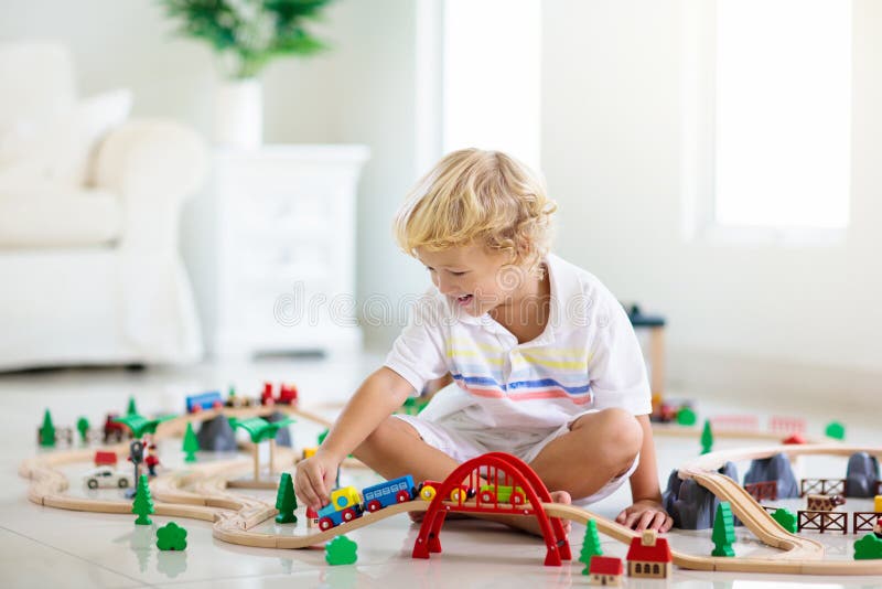 Kids play wooden railway. Child with toy train stock images Kids play wooden railway. Child with toy train stock images
