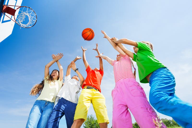 Kids playing basketball with a ball up in sky