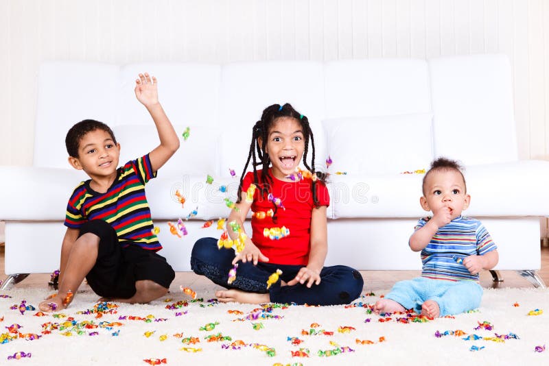 Laughing african american kids playing with candies