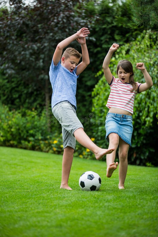 Kids playing with football in park stock photos Kids playing with football in park stock photos