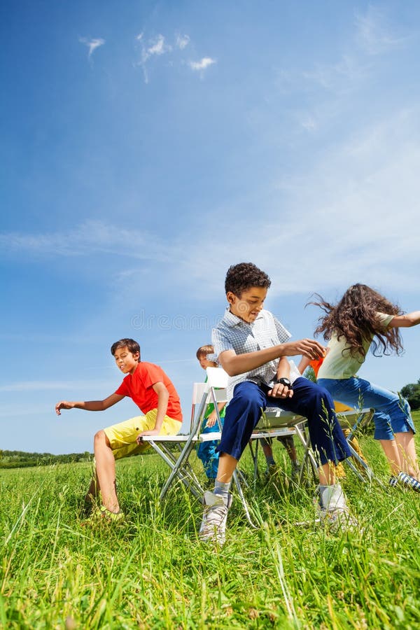 Kids Playing Game and Sit Fast on Chairs Outside Stock Image Image of
