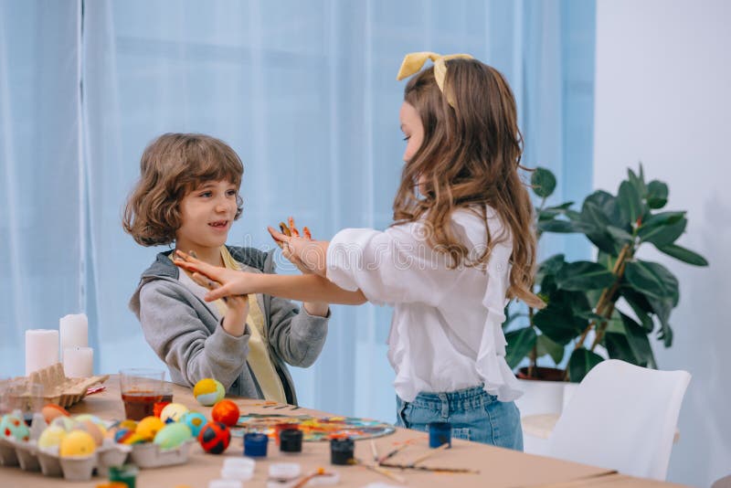 kids playing while painting easter eggs