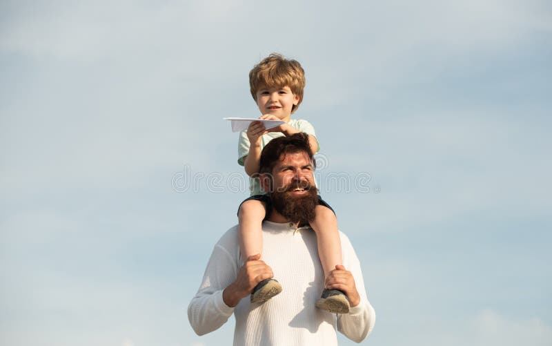 Kids playing with simple paper planes on sunny day. Family dreams of traveling. Father and son playing outdoors. People stock images Kids playing with simple paper planes on sunny day. Family dreams of traveling. Father and son playing outdoors. People stock images