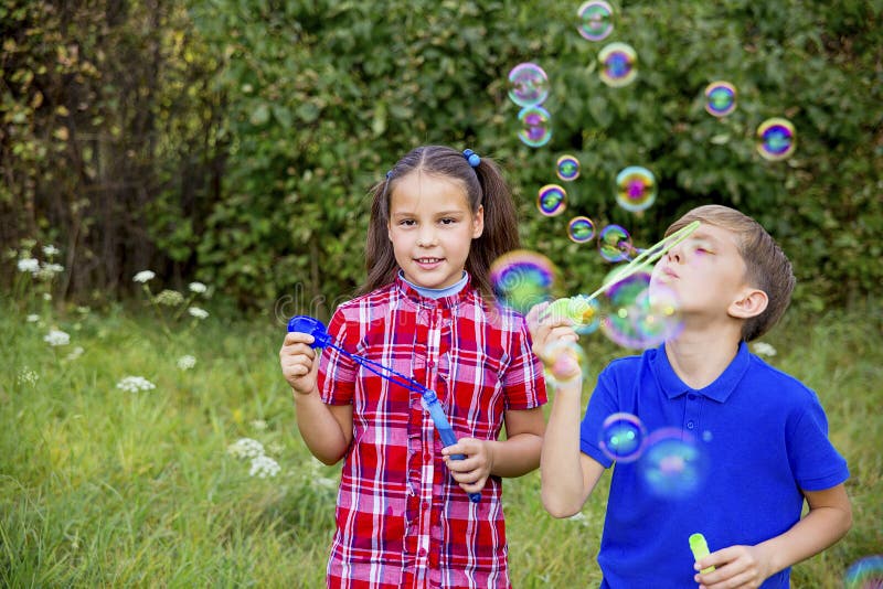 Kids playing with bubbles stock photo. Image of little 105187378