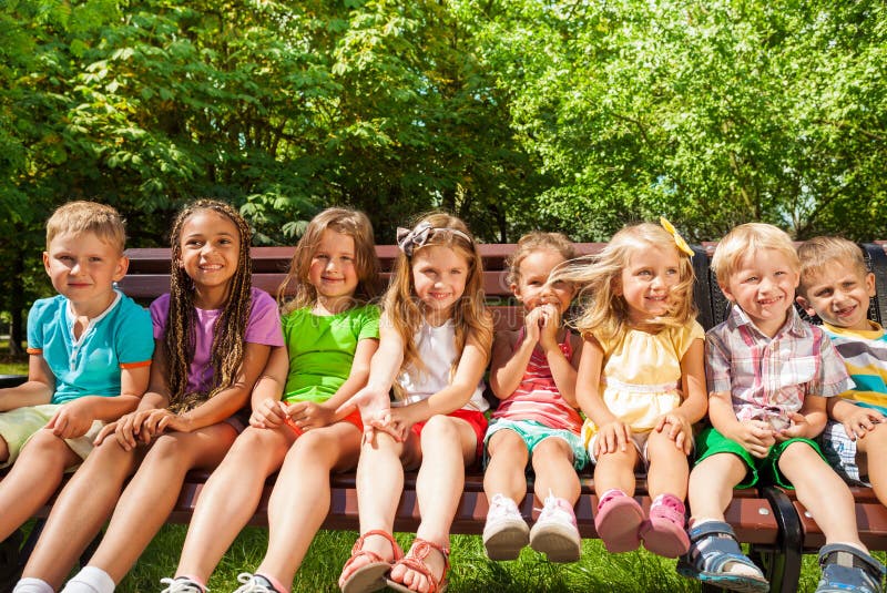 Kids in row on the bench, summer park