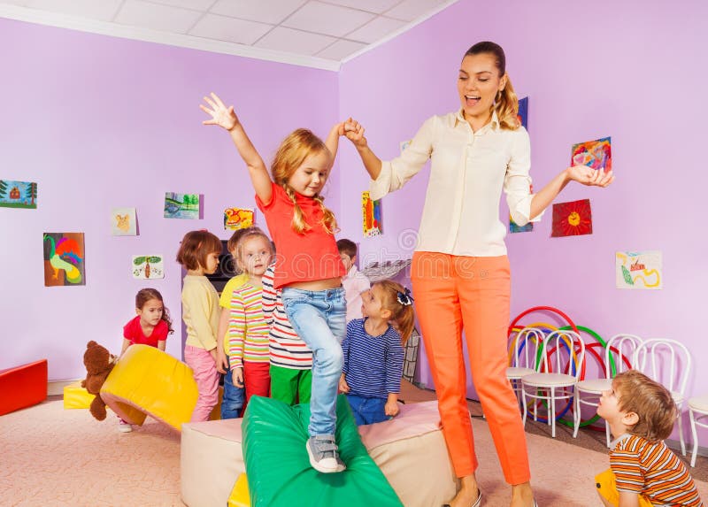 Kids run, climb around soft block in active class stock photos Kids run, climb around soft block in active class stock photos
