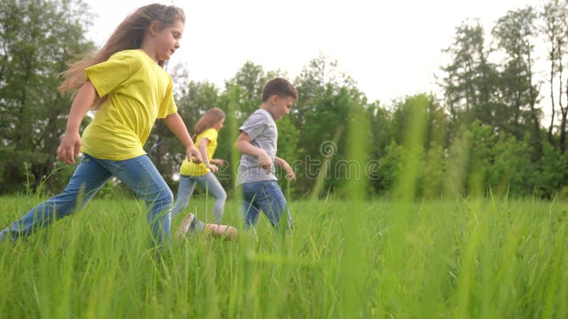 Kids run to the park. happy family a children kid together run in the park at sunset. people in fun the park concept