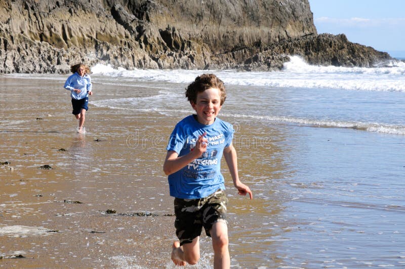 Kids running along the beach