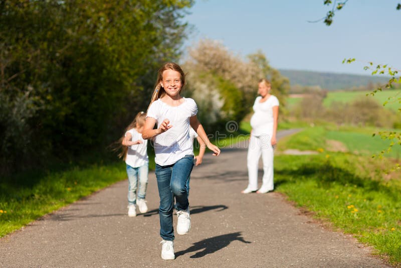 Kids running in spring, mother standing