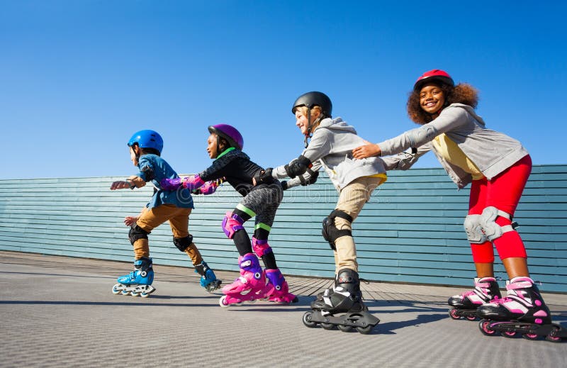 Kids in safety helmets rollerblading on the track