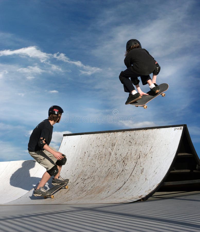 Dívka a chlapec na skateboardu.