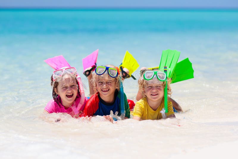 Kids snorkel. Children snorkeling in tropical sea. Kids snorkel. Beach fun. Children snorkeling in tropical sea on family summer vacation on exotic island. Child