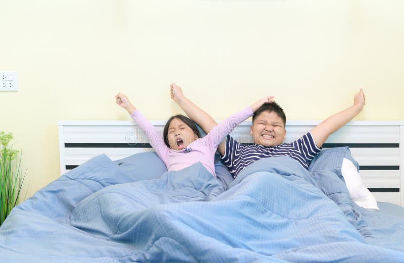 Kids are stretching in bed after waking up stock image Kids are stretching in bed after waking up stock image