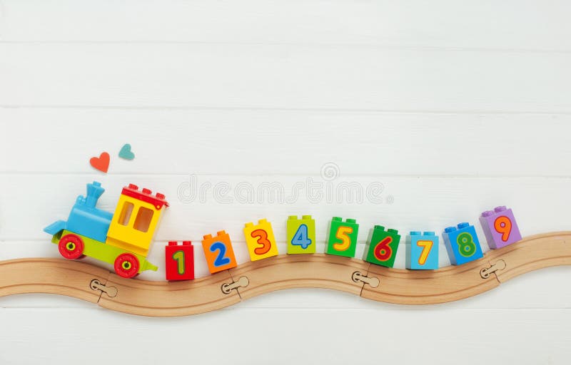 Kids toy train with numbers on railway on white wooden background with copy space royalty free stock image Kids toy train with numbers on railway on white wooden background with copy space royalty free stock image