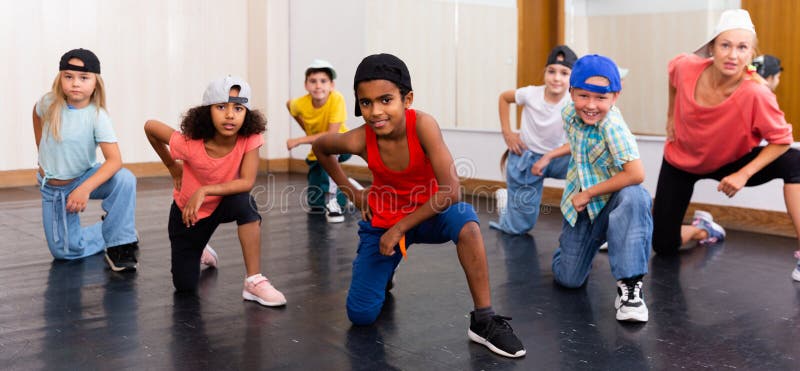 Positive girls and boys training hip hop in dance studio, dance classes for kids. Positive girls and boys training hip hop in dance studio, dance classes for kids