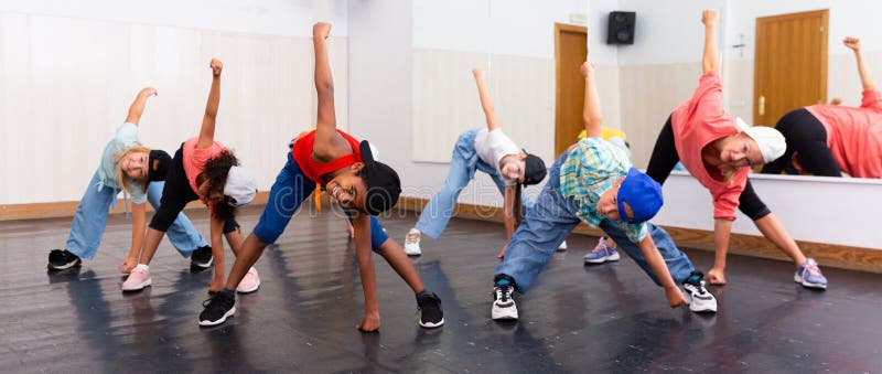 Smiling girls and boys hip hop dancers doing dance workout during group class. Smiling girls and boys hip hop dancers doing dance workout during group class