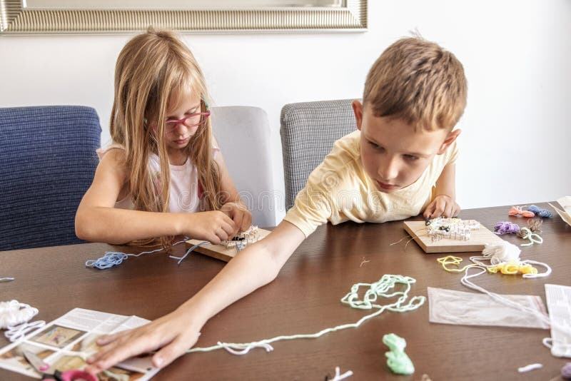 Kids use thread and nails to make shapes. They build skills, learn new things, and enjoy creative time. royalty free stock image