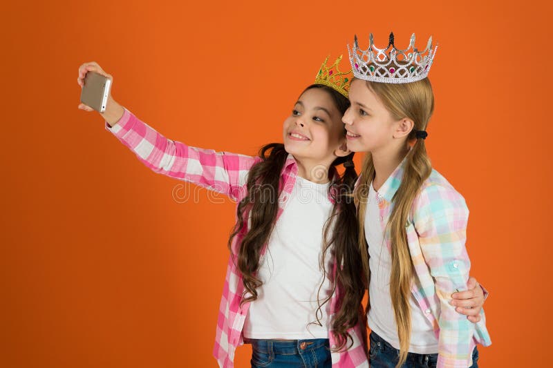 Kids wear golden crowns symbol princess. Warning signs of spoiled child. Avoid raising spoiled kids. Girls taking selfie