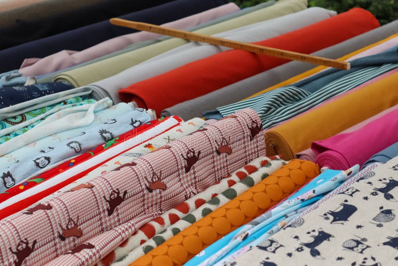 Kiel, Germany - 16. October 2022: Samples of cloth and fabrics with price signs in different colors found at a fabrics market. Kiel, Germany - 16. October 2022: Samples of cloth and fabrics with price signs in different colors found at a fabrics market.