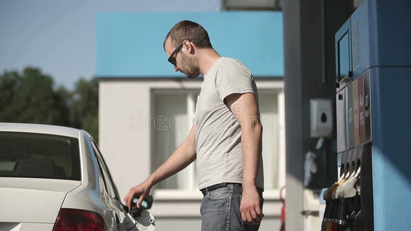 Kierowca pompuje benzynę przy benzynową stacją